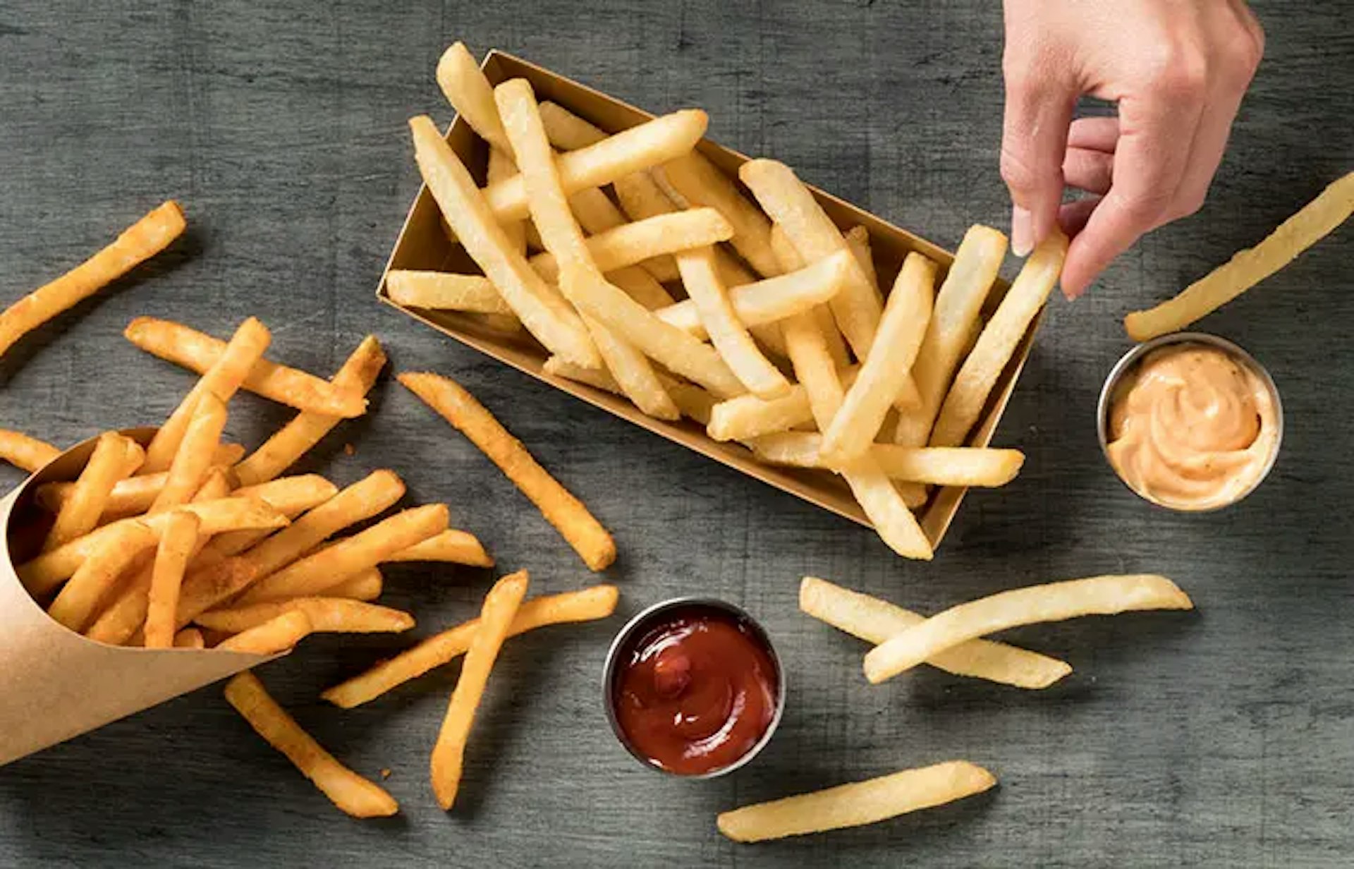 Hand reaching down to grab a Simplot Conquest® Delivery+™ Fry